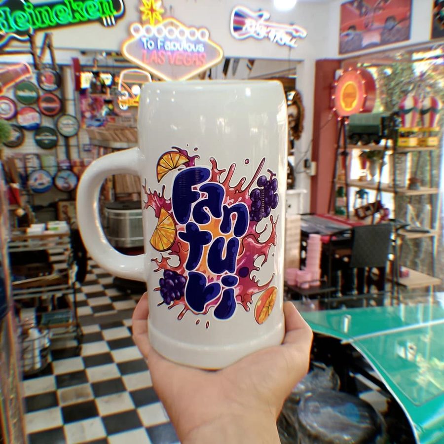 Jarra cervecera blanca con letras coloridas
