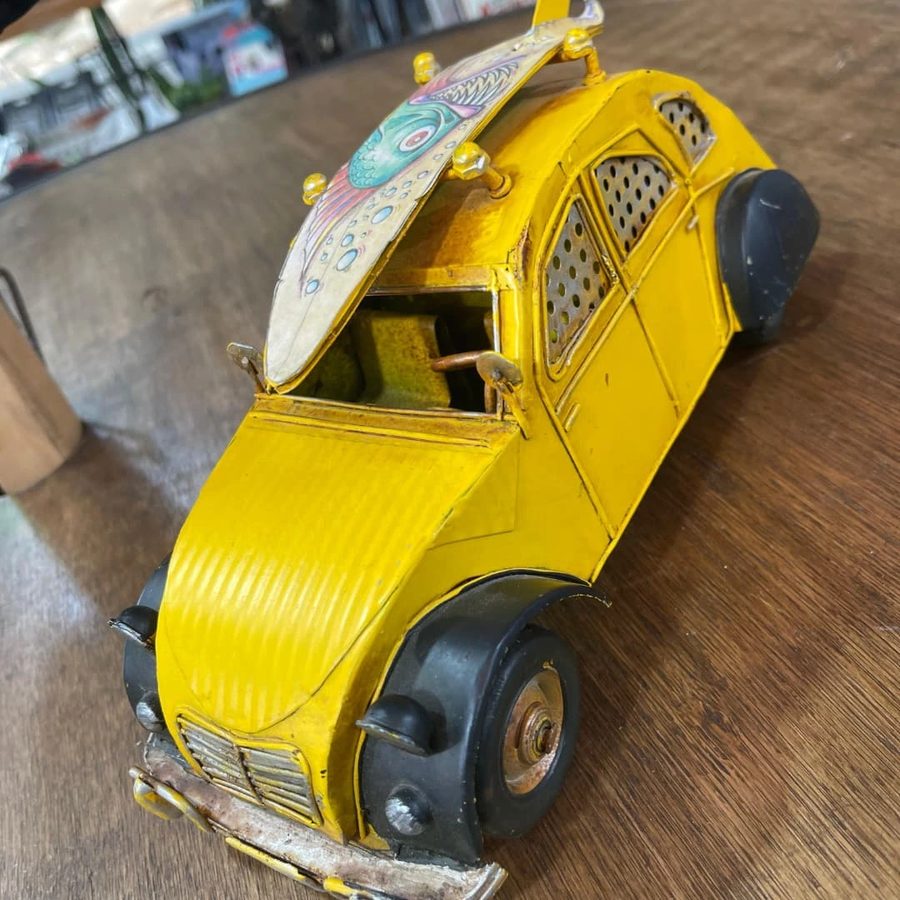 Citroën 2CV amarillo con tabla de surf